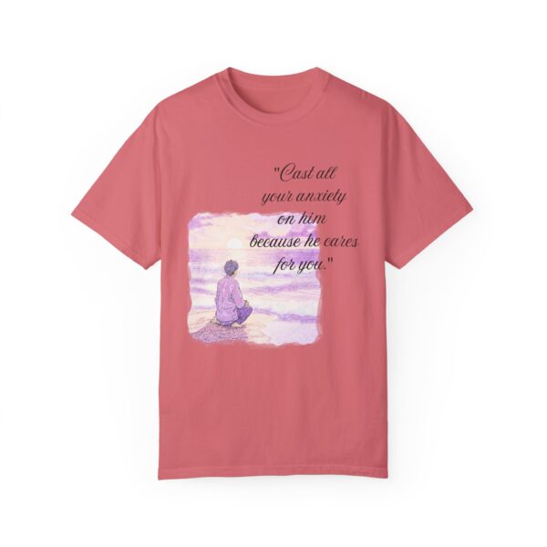 the front of a salmon t-shirt with text on it and a calm guy sitting at a beach